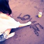 砂浜にLOVEと書く女性